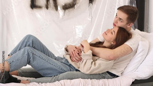 Young guy and girl are in love with each other and spend time together on bed just hugging. Pure first love. 4K Resolution