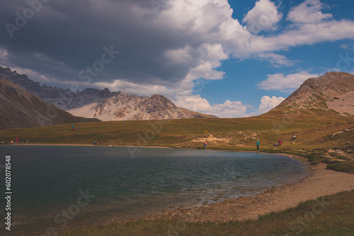 People resting around the mountain lake Lac de Soulier in the Queyras valley in the Alps (Hautes-Alpes, France)