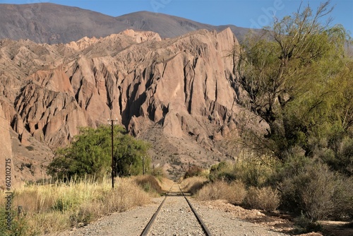 desert railway leading to the red mountains of Salta in Argentina
