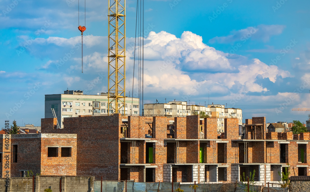 Construction of a new multi-storey red brick building, construction crane Construction of a new multi-storey red brick building, construction crane