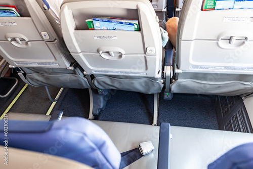 Economy class seats in the aircraft cabin with a small distance between the seats.