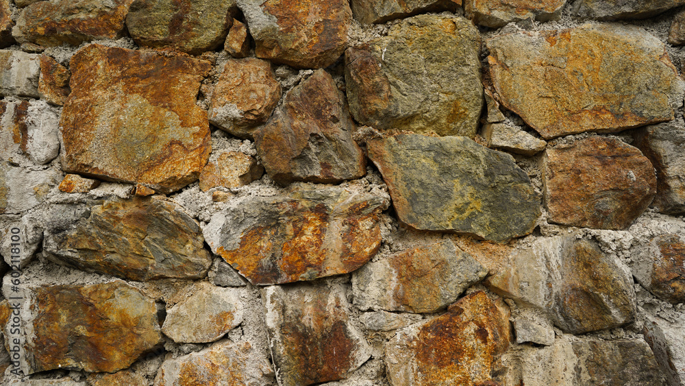 Aged masonry rock wall texture, brown rock, rock wall surface. Texture of the ancient dilapidated wall fencing in the old town. Stone wall background, front view Aged masonry rock wall texture, brown rock, rock wall surface. Texture of the ancient dilapidated wall fencing in the old town. Stone wall background, front view