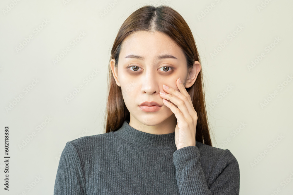 Bored, insomnia asian young woman, girl looking at camera, hand touching under eyes with problem of black circles or panda puffy, swollen and wrinkle on face. Sleepless, sleepy healthcare person. Bored, insomnia asian young woman, girl looking at camera, hand touching under eyes with problem of black circles or panda puffy, swollen and wrinkle on face. Sleepless, sleepy healthcare person.