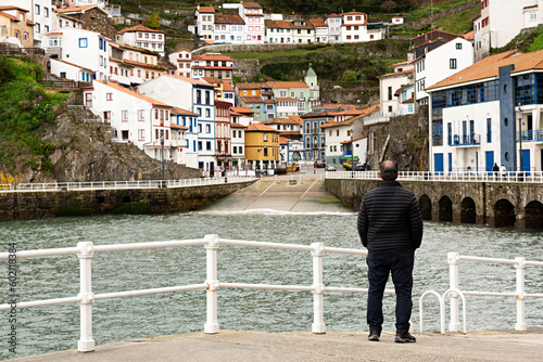 Hombre observando el pueblo de Cudillero en Asturias, España. photo
