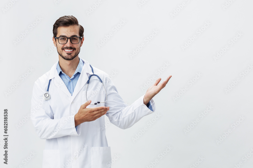 Man doctor in white coat and eyeglasses smile shows hand gestures signs on white isolated background looks into camera, copy space, space for text, health Man doctor in white coat and eyeglasses smile shows hand gestures signs on white isolated background looks into camera, copy space, space for text, health