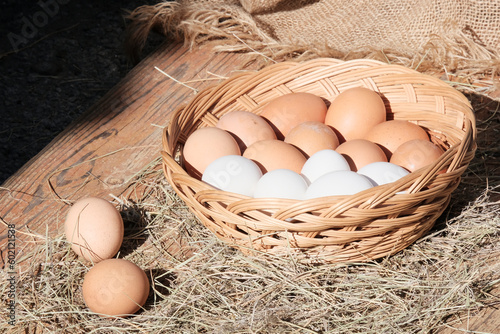 Brown eggs in a light wooden basket. Farm food product. Beautiful sunny background with eggs.