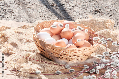 Brown eggs in a light wooden basket. Farm food product. Beautiful sunny background with eggs.