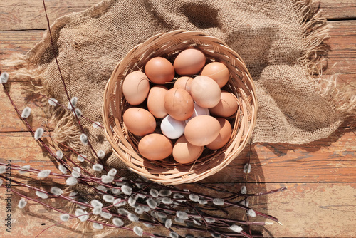 Brown eggs in a light wooden basket. Farm food product. Beautiful sunny background with eggs.