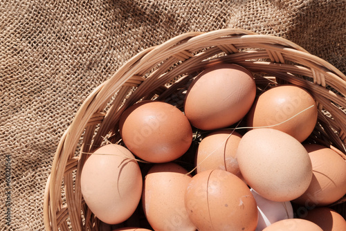 Beautiful brown colored eggs in a wooden basket in sunlight. Farmer's market, Egg price, increase. dietary product. Beautiful background with eggs.