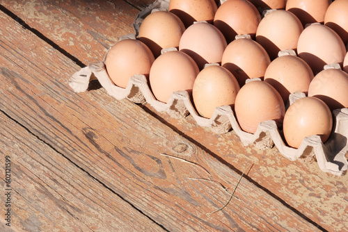 Brown eggs in a box. Farm food product. Beautiful sunny background with eggs.