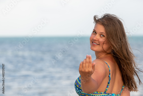 Cheerful Young Woman in Swimsuit on the Beach, Waving and Calling with Hand