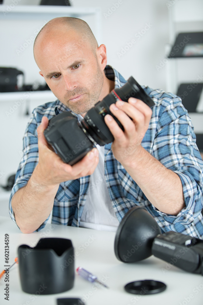 male repairing an camera at his workplace male repairing an camera at his workplace