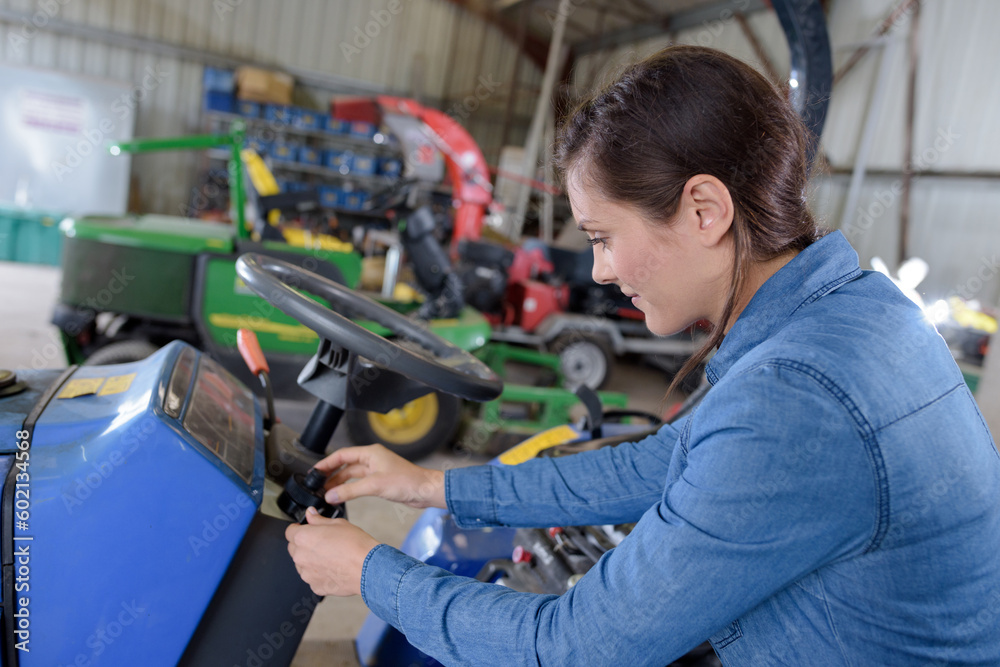 female mechanic working on lawnmower in workshop female mechanic working on lawnmower in workshop