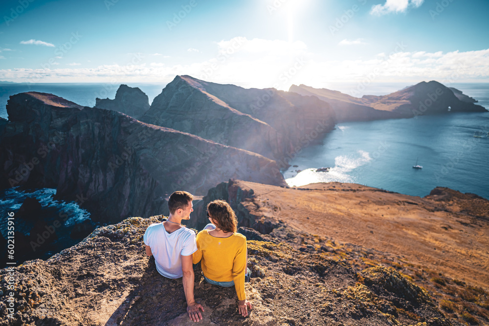 Back view of a young tourist couple enjoying the coastal landscape of Madeira Island in the Atlantic Ocean in the morning. São Lourenço, Madeira Island, Portugal, Europe.