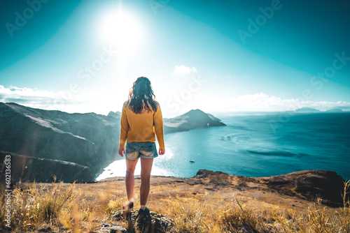 Tourist on a hill overlooking the coastal landscape of Madeira Island in the Atlantic Ocean in the morning. São Lourenço, Madeira Island, Portugal, Europe. © Michael