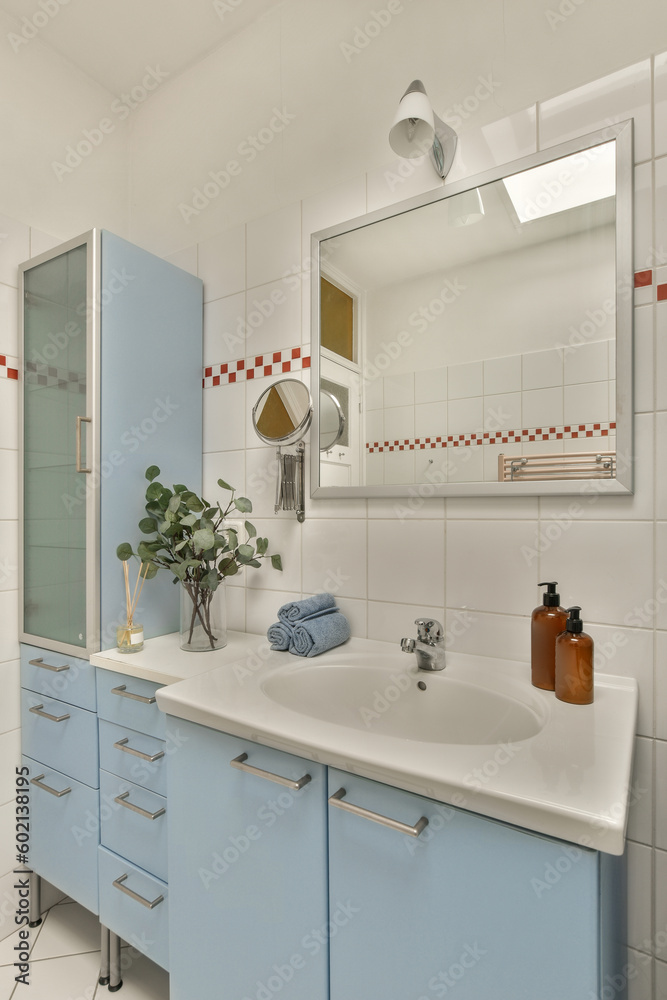a modern bathroom with blue cabinets and white tiles on the walls, along with a large mirror over the sink