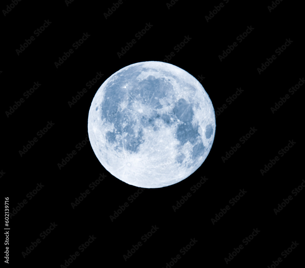 Fototapeta premium As the morning sky begins to lighten, a magnificent sight slowly emerges on the horizon - the full moon, casting its radiant glow upon the world below. The moon appears larger than usual.