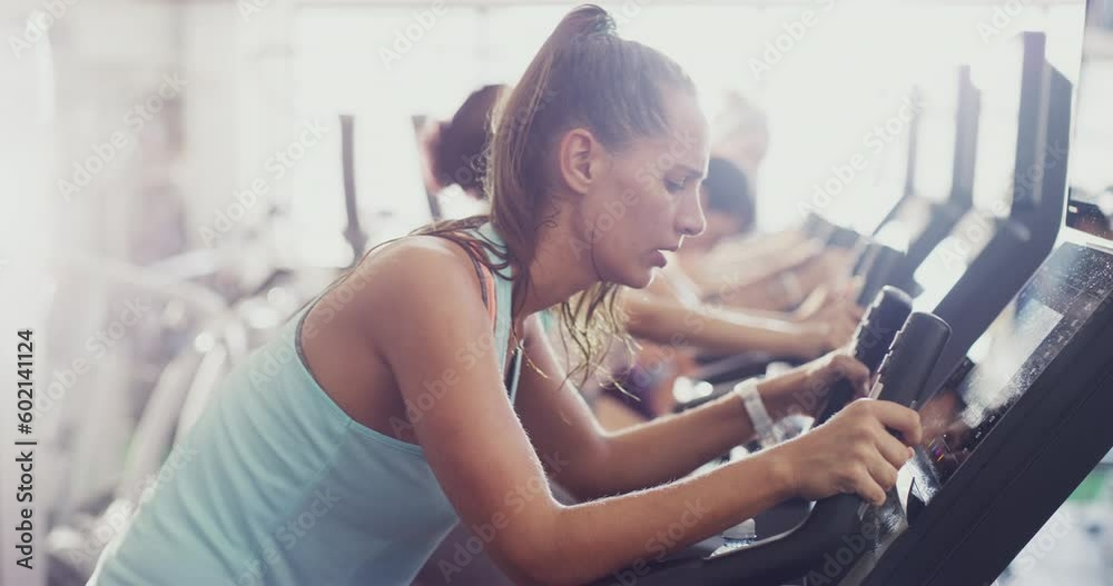 Gym, exercise bike and women cycling for fitness workout on spinning class stationary machine. People group together to focus on cardio sports training with energy, motivation and speed for wellness