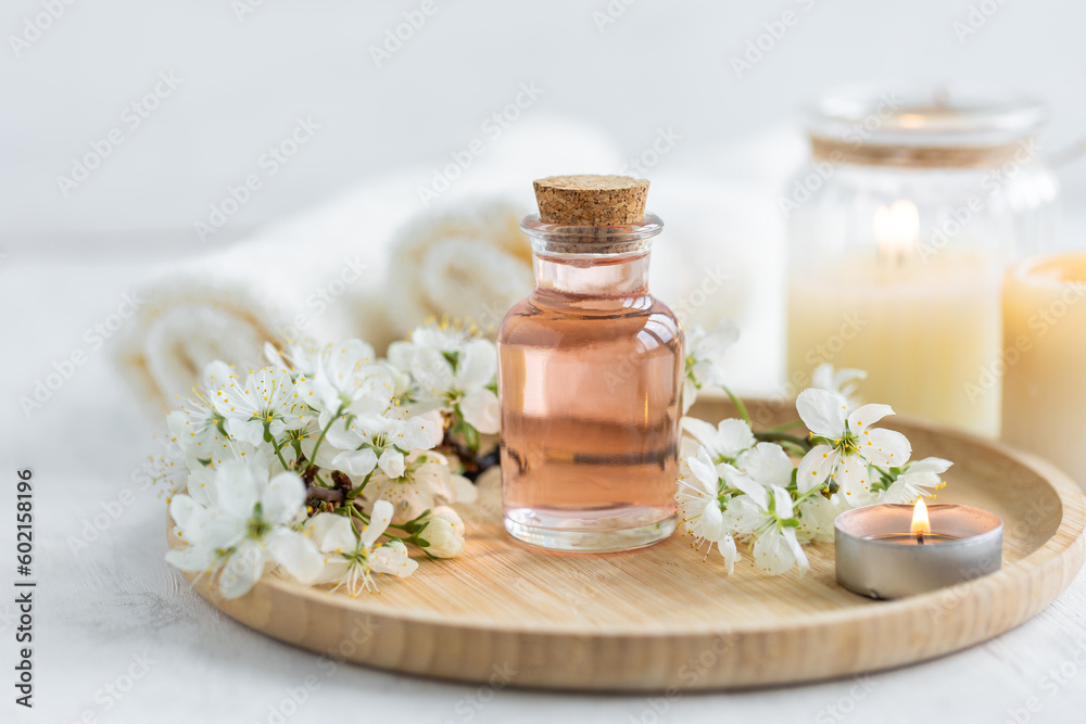 Natural fresh perfume with the scent of apple tree blooming flower on wooden bamboo tray. Aromatherapy, wellness, luxury perfumery concept. Organic ingredients for toilet water and essential oils Natural fresh perfume with the scent of apple tree blooming flower on wooden bamboo tray. Aromatherapy, wellness, luxury perfumery concept. Organic ingredients for toilet water and essential oils