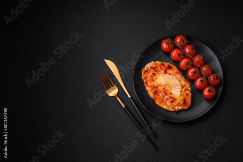 Grilled chicken fillet in the form of a steak with tomatoes, pineapple and cheese