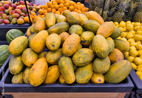 Fototapeta Naklejka Na Ścianę i Meble -  Tropical fruits on display in supermarket. Papayas, lemons, mangos, watermelons, pineapples. 