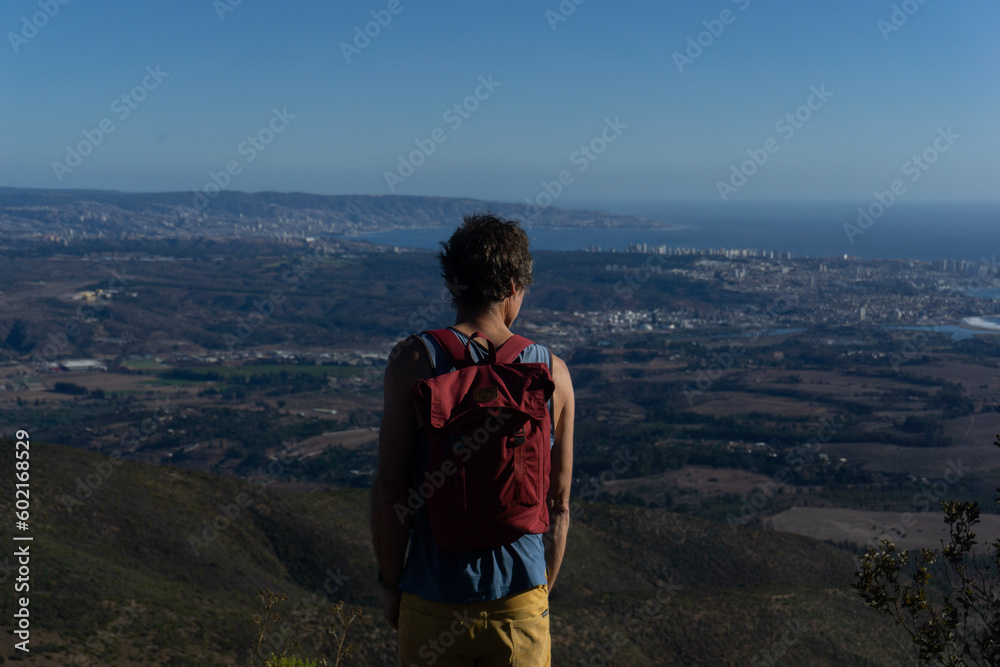 hermoso hombre observando el mar después de un trekking