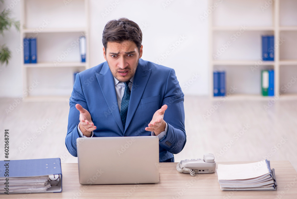 Young male employee working in the office Young male employee working in the office
