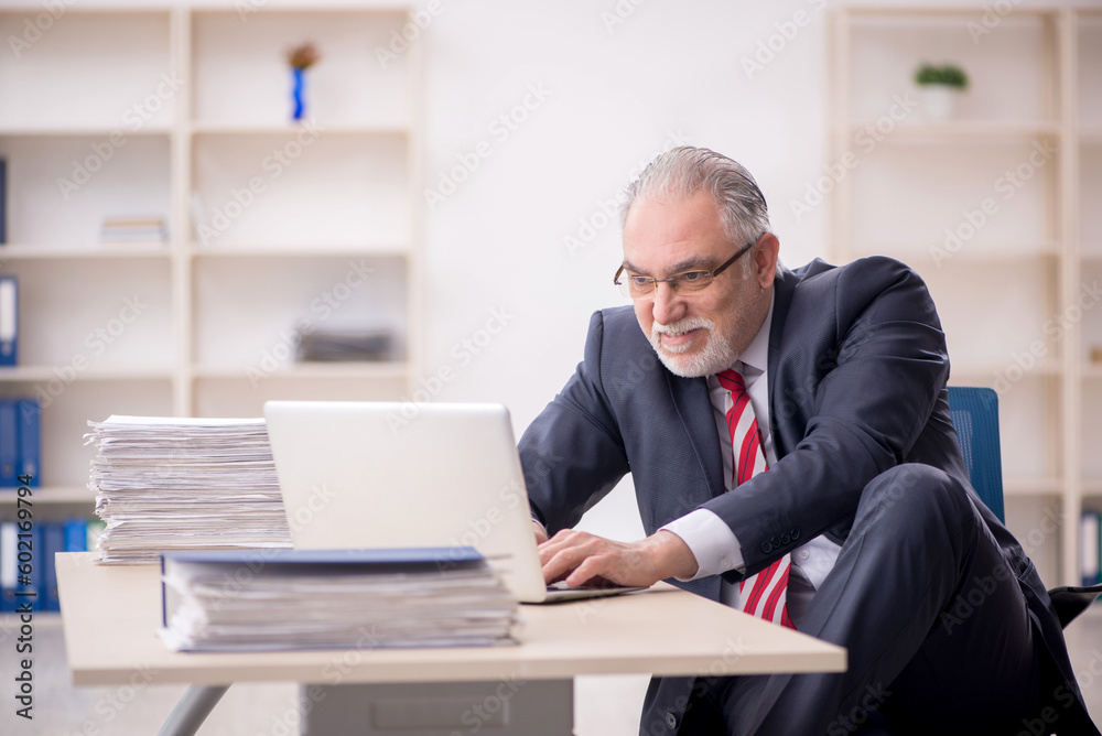 Old male employee and too much work at workplace Old male employee and too much work at workplace