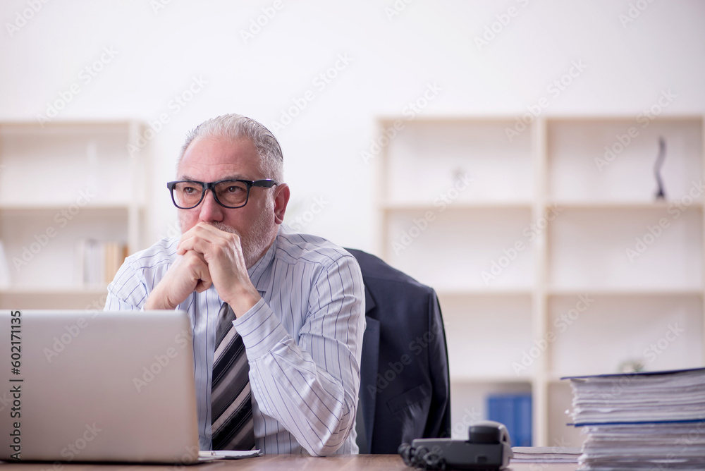 Old male employee and too much work at workplace Old male employee and too much work at workplace