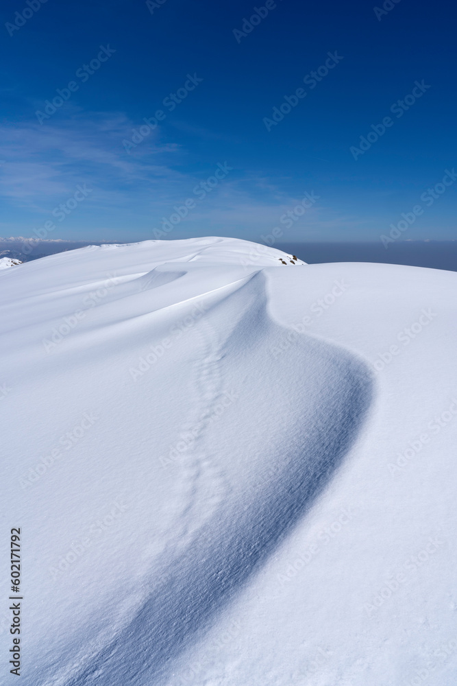 snowdrifts on top of the alpine mountain. snow dune lines, texture and shapes background