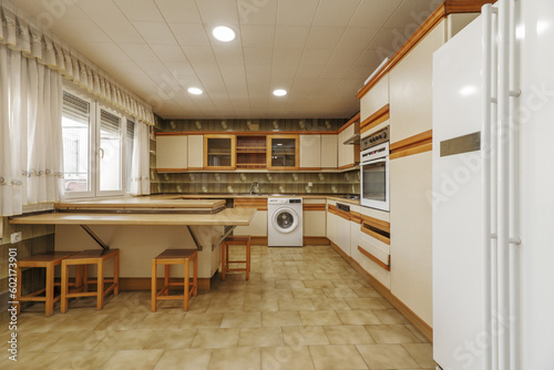 A square kitchen with cabinets along two walls and a large island © Toyakisfoto.photos