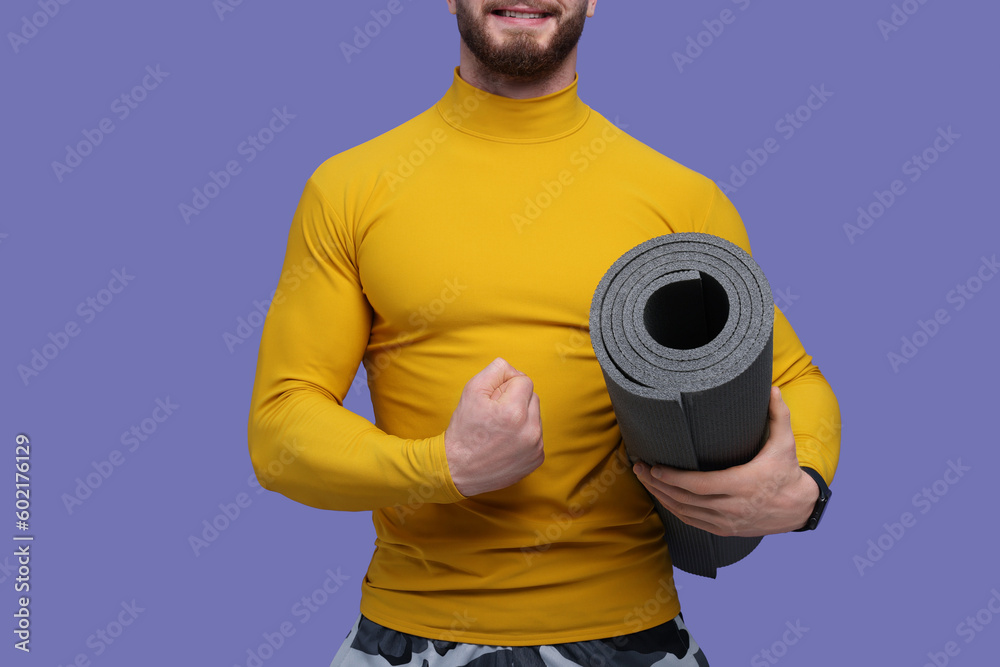 Man with fitness mat on purple background, closeup Man with fitness mat on purple background, closeup