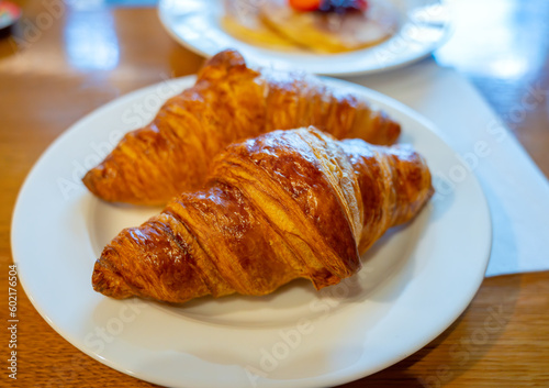 Two fresh baked puff croissants  traditional French breakfast