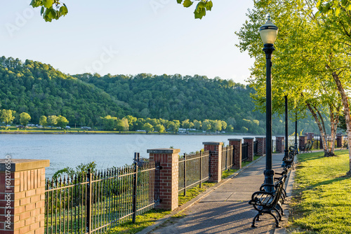 Billede på lærred Walkway along the Ohio River in Madison, Indiana with a wrought iron fence and lamp posts in the evening