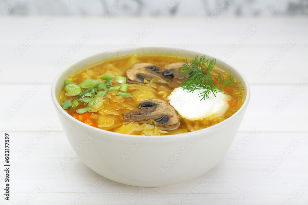 Delicious sauerkraut soup with mushrooms, green onion, dill and sour cream on white table Delicious sauerkraut soup with mushrooms, green onion, dill and sour cream on white table