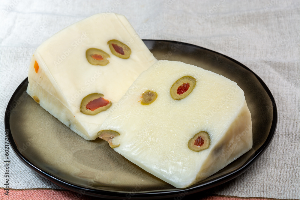 Cheese collection, fresh Italian pecorino cheese made from sheep milk filled with green olives stuffed with red sweet paprika