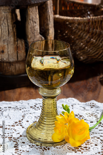 Antique German glassware, old Dutch style rummer or roemer glasses with white wine on white lace tablecloth photo