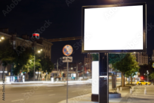 Large horizontal billboard in the night city. Road, tracks of lanterns of moving cars. Mock-up.