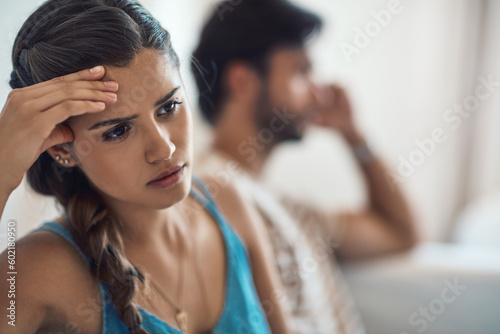 Unhappy, upset or sad with a couple arguing on a sofa in their home living room about an affair or breakup. Depression, abuse or domestic violence with a woman thinking about divorce after a fight