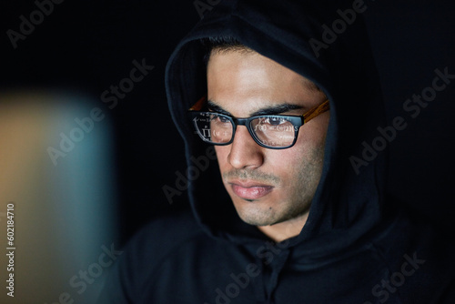 Hacking, computer and hacker man in hoodie programming, coding software and information technology in dark room. Code analysis, night cybersecurity and programmer or focus person hacking data on pc