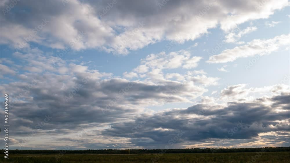 Fluffy grey clouds flying quickly over landscape with yellow steppe and forest, casting shadows on ground. Timelapse with cloudscape, grass, trees, shrubs and low line of horizon. 4K UHD 4096x2304 Fluffy grey clouds flying quickly over landscape with yellow steppe and forest, casting shadows on ground. Timelapse with cloudscape, grass, trees, shrubs and low line of horizon. 4K UHD 4096x2304