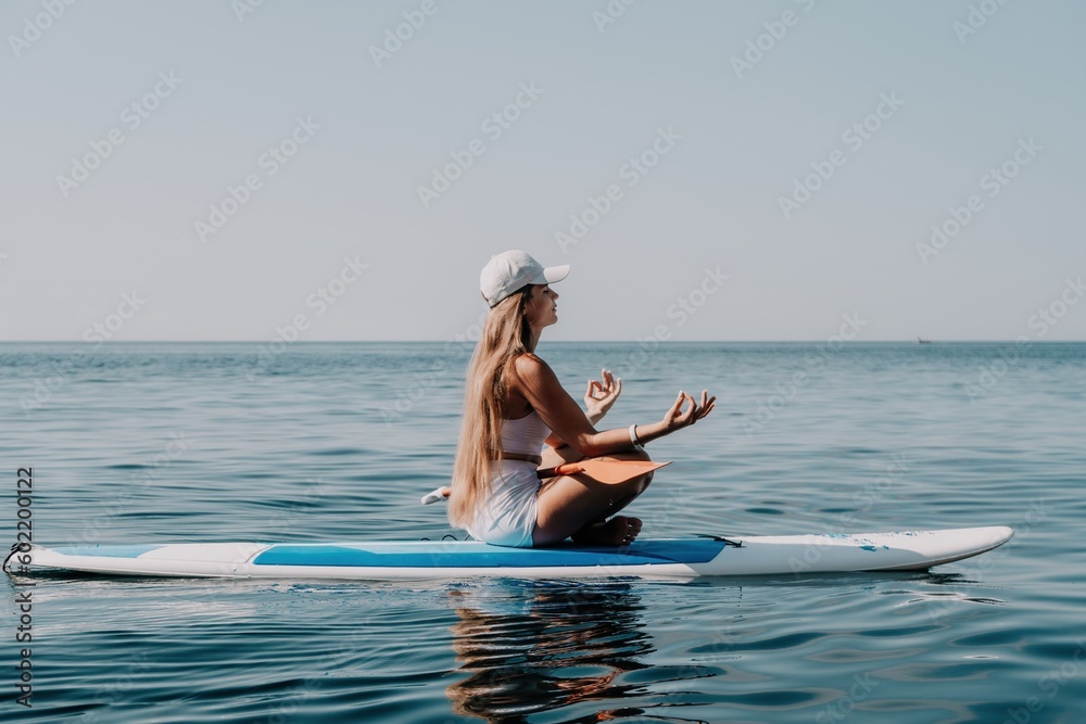 Woman sea sup. Close up portrait of happy young caucasian woman with long hair looking at camera and smiling. Cute woman portrait in bikini posing on sup board in the sea