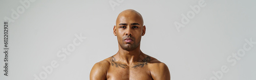 Portrait of attractive sporty man with muscled naked body on white studio background