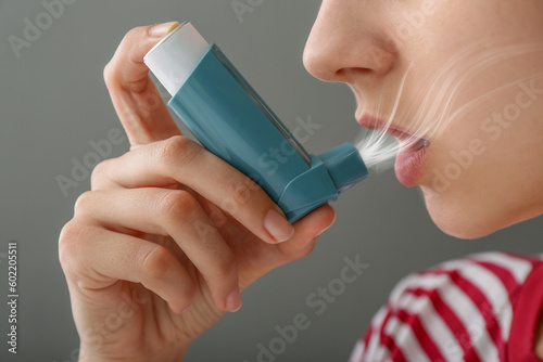Young woman using inhaler o...