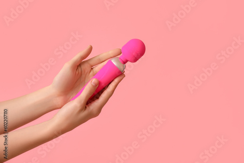 Woman with vibrator from sex shop on pink background photo