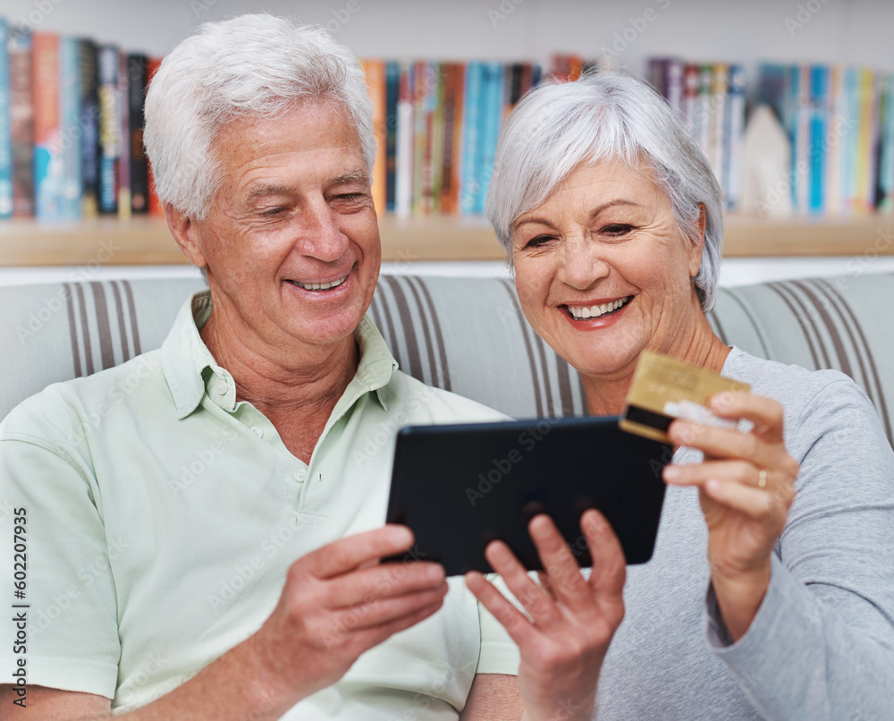 Happy senior couple, tablet and credit card for online shopping on living room sofa together at home. Elderly man and woman smiling on technology for ecommerce, banking app or payment on lounge couch Happy senior couple, tablet and credit card for online shopping on living room sofa together at home. Elderly man and woman smiling on technology for ecommerce, banking app or payment on lounge couch
