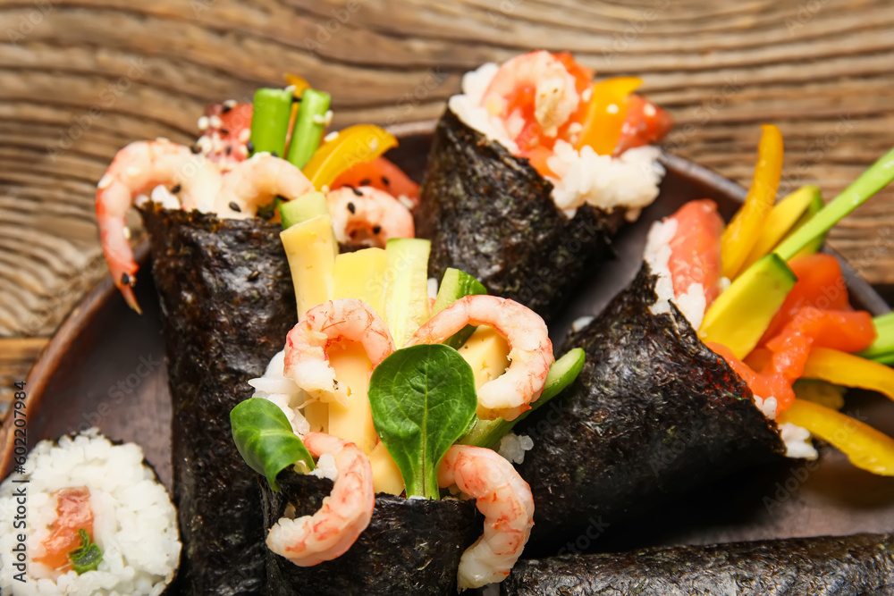 Plate with tasty sushi cones on wooden background, closeup Plate with tasty sushi cones on wooden background, closeup