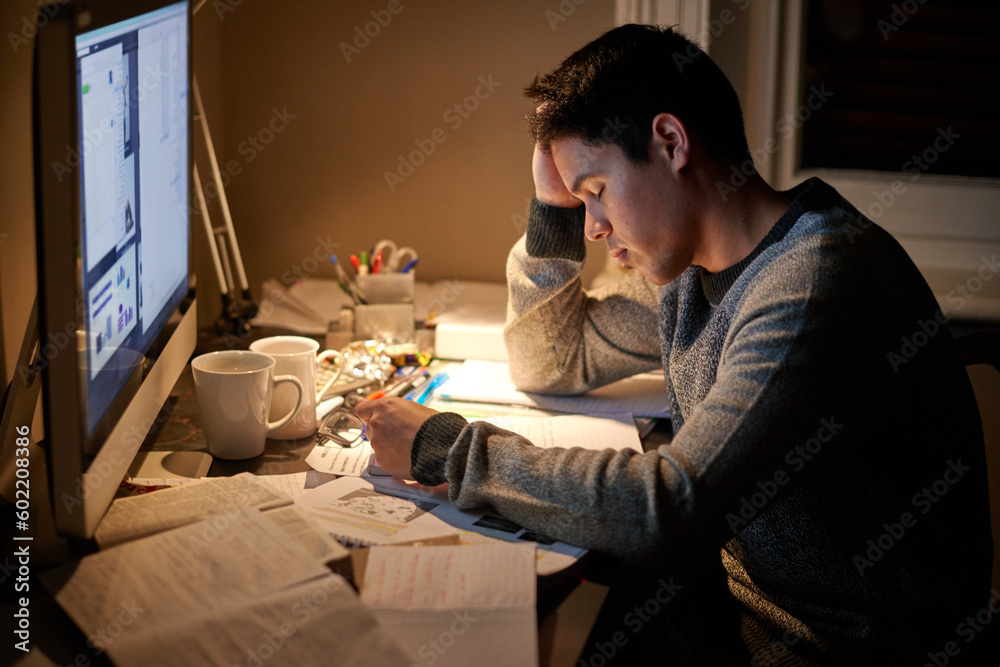 Man, studying and tired in night by computer for test, assessment or stress in college dorm room. Male university student, education and burnout with fear, fatigue and anxiety with books for learning