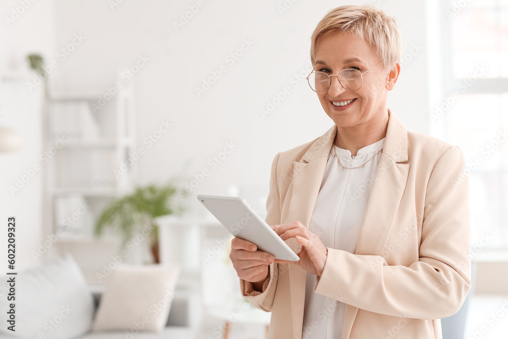 Mature psychologist working with tablet computer in office Mature psychologist working with tablet computer in office