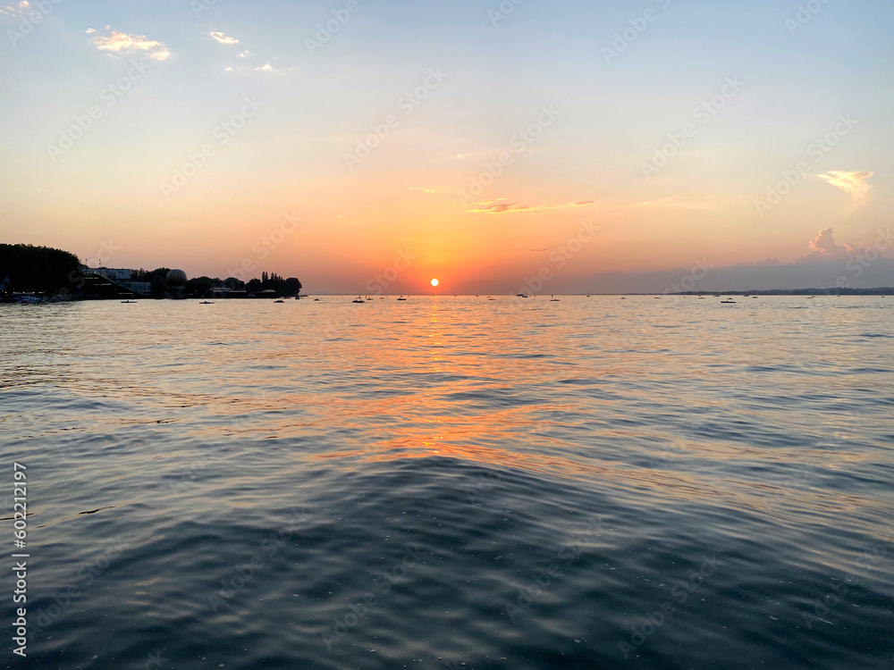Obraz premium Beautiful sunset on a summer evening seen from border of lake Bodensee at City of Bregenz. Photo taken August 15th, 2021, Bregenz, Austria.